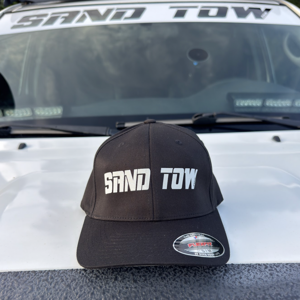 Black cap with 'SAND TOW' text on a vehicle