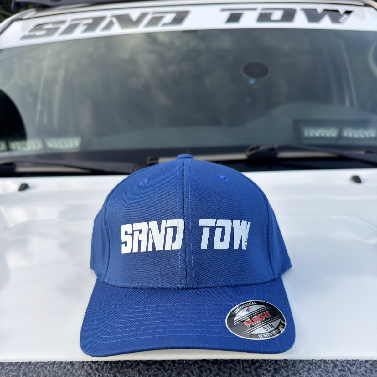 Blue cap with 'SAND TOW' text on a vehicle's open hood