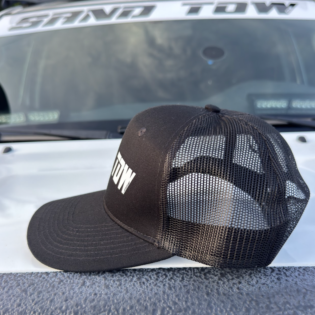 Black and brown cap with 'TOW' text on a vehicle's hood