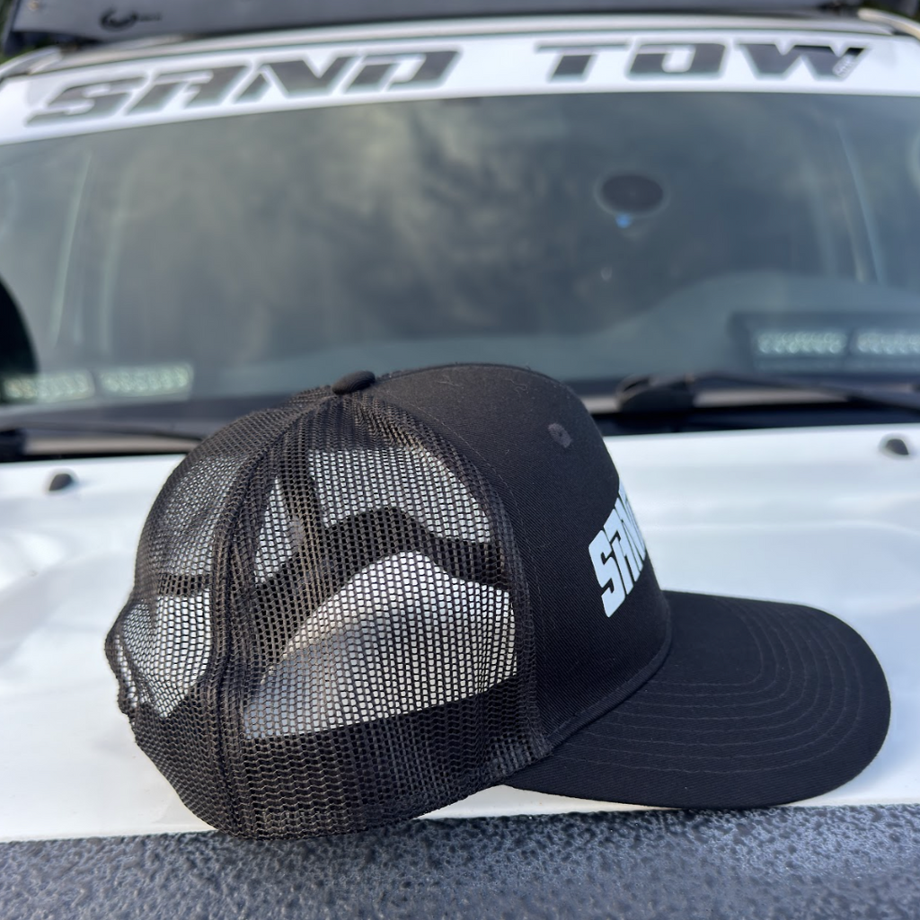 Black cap with mesh design on a vehicle's open trunk